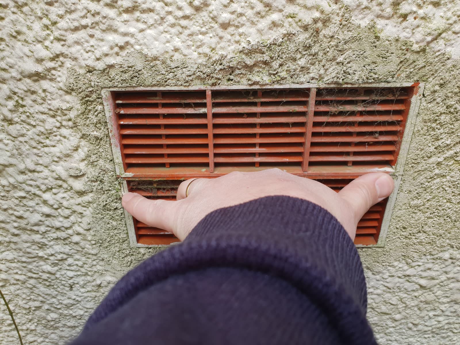 External wall vent set into rendered wall with brick surroundings