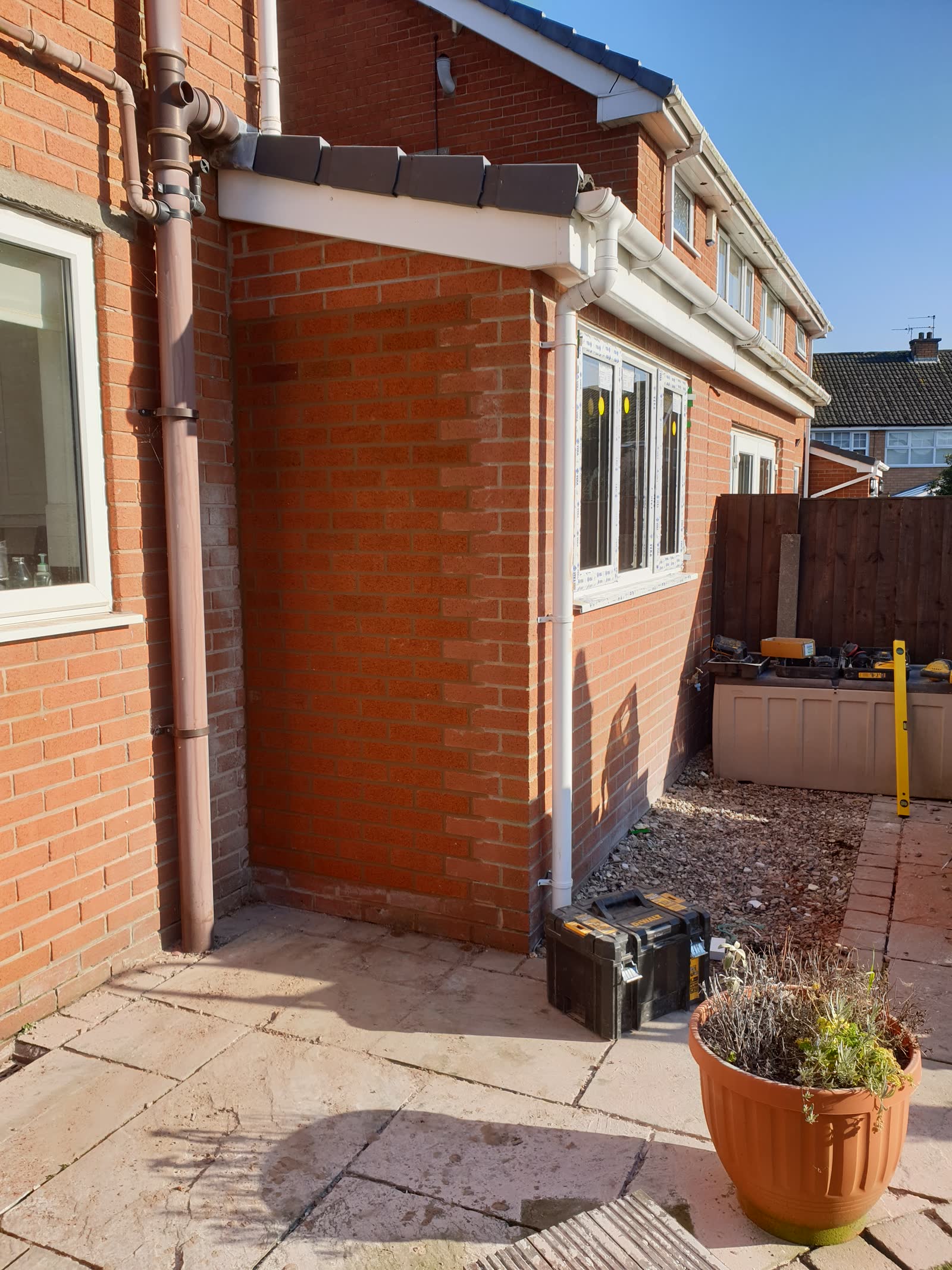 Completed single-storey red brick extension with new window and white guttering